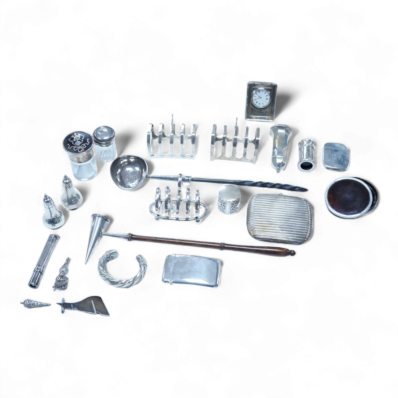 A group of assorted silver, to include a pair of modern five bar toast racks, a George V card case, a sterling vesta case, four assorted condiments, two mounted toilet bottles, mounted timepiece, a modern wooden handled